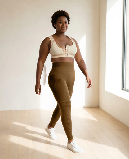 A woman in her forties in the beige bra and coffee leggings, walking in a sunny room