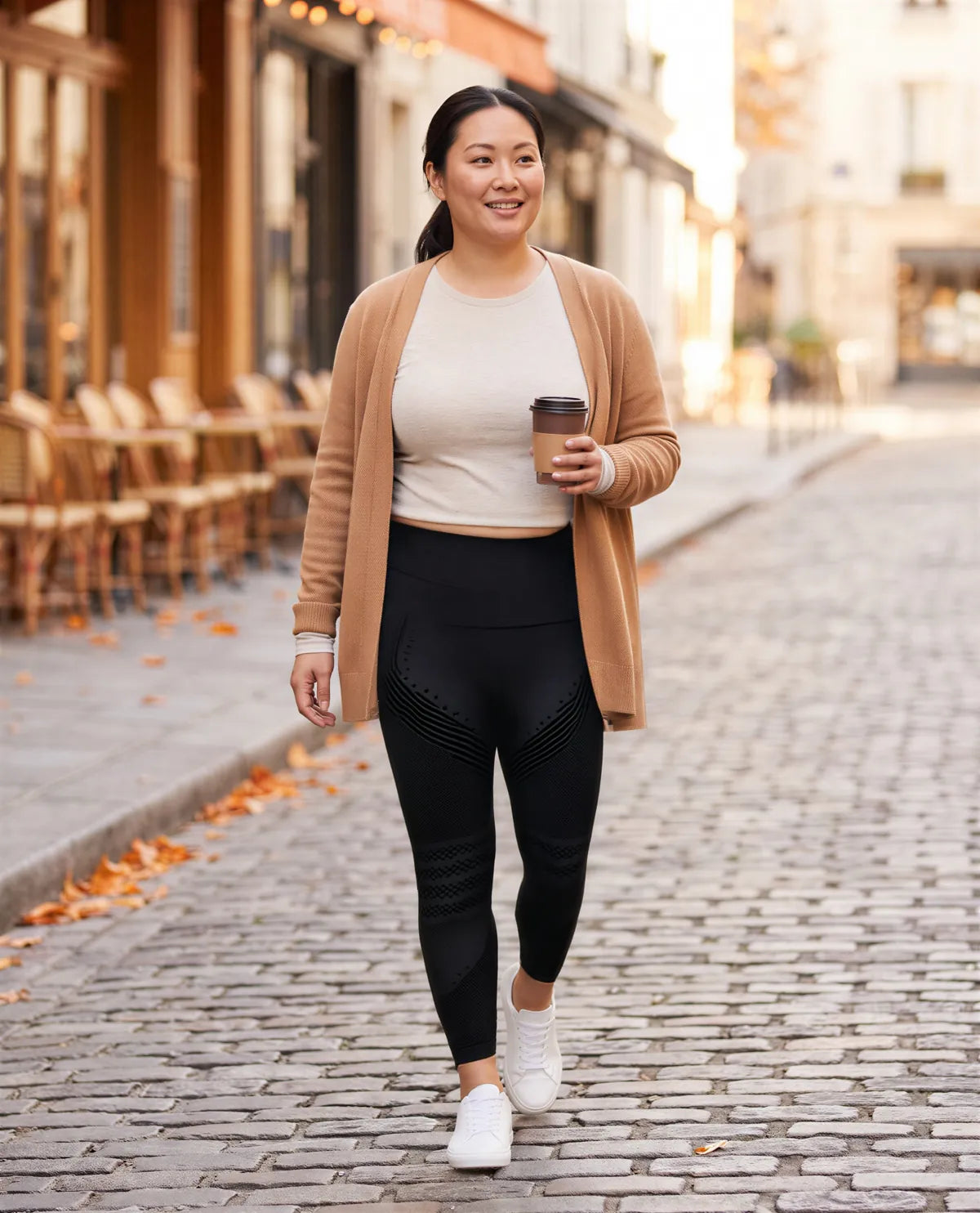 Coffee in hand on a cafe street, in black leggings